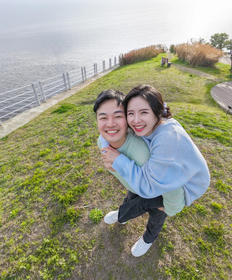 바닷가 언덕에서 서로 업고 웃는 주형과 서윤