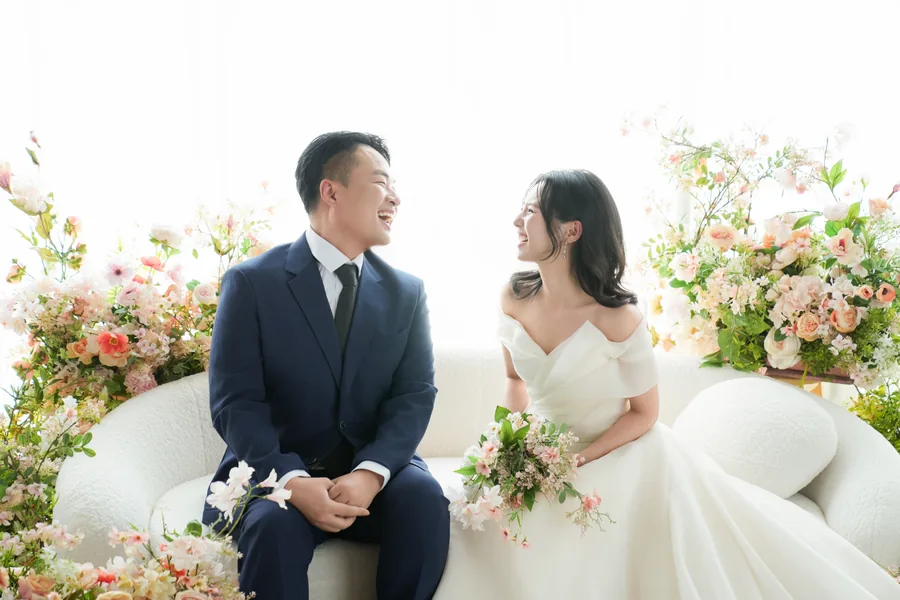 꽃 사이에 나란히 앉아 서로 바라보는 주형과 서윤