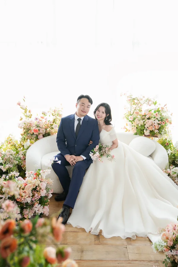 꽃으로 둘러싸인 의자에 나란히 앉은 주형과 서윤